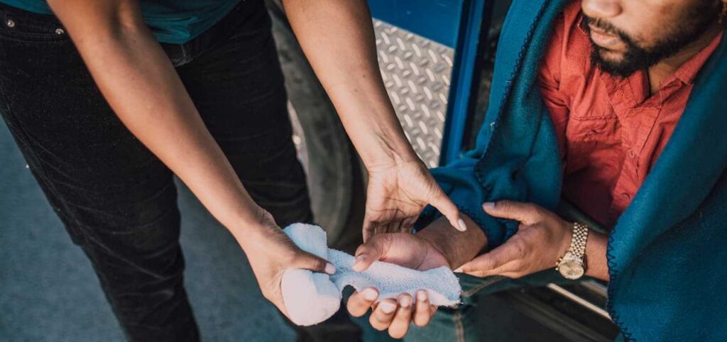 Injured man getting medical treatment after a car crash