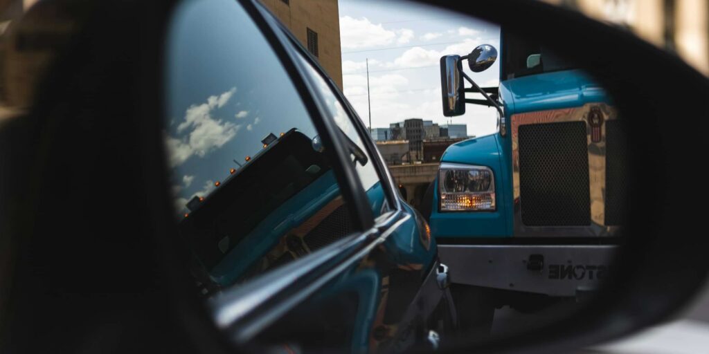 large semi-truck in car rearview mirror