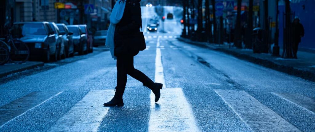 woman crossing street in crosswalk