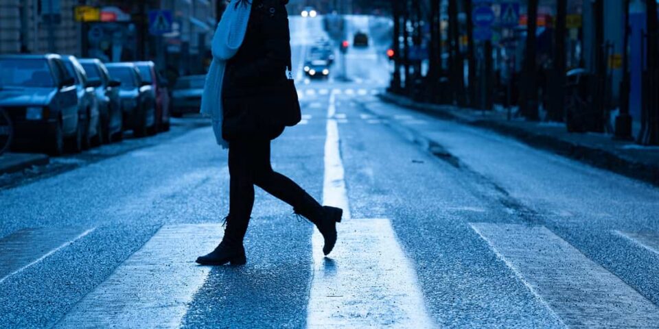 woman crossing street in crosswalk