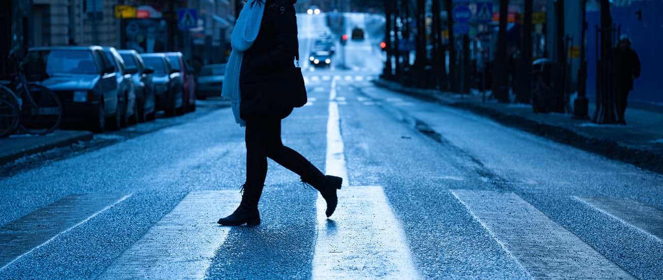 woman crossing street in crosswalk
