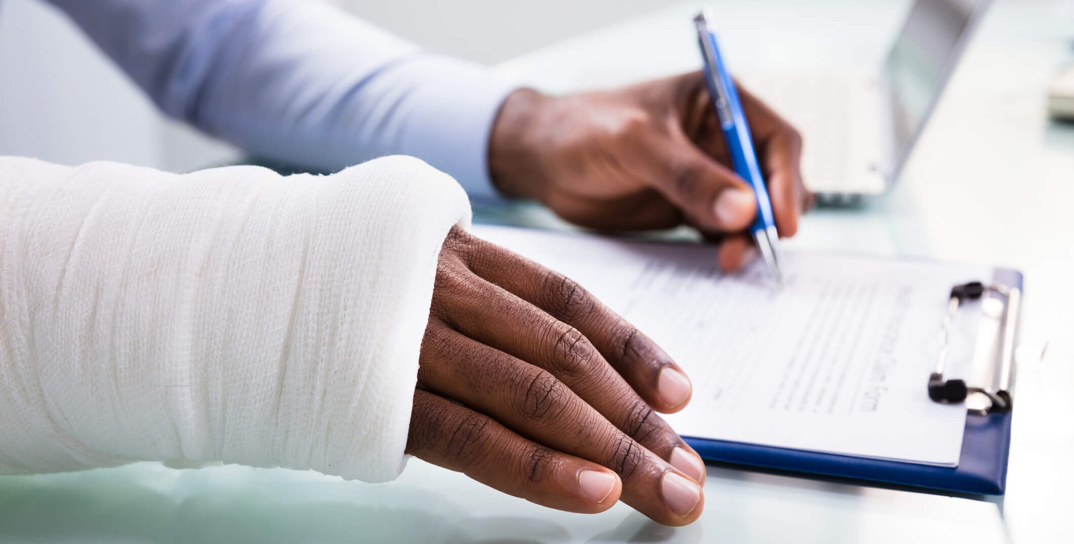 man with broken arm in cast filling out paperwork